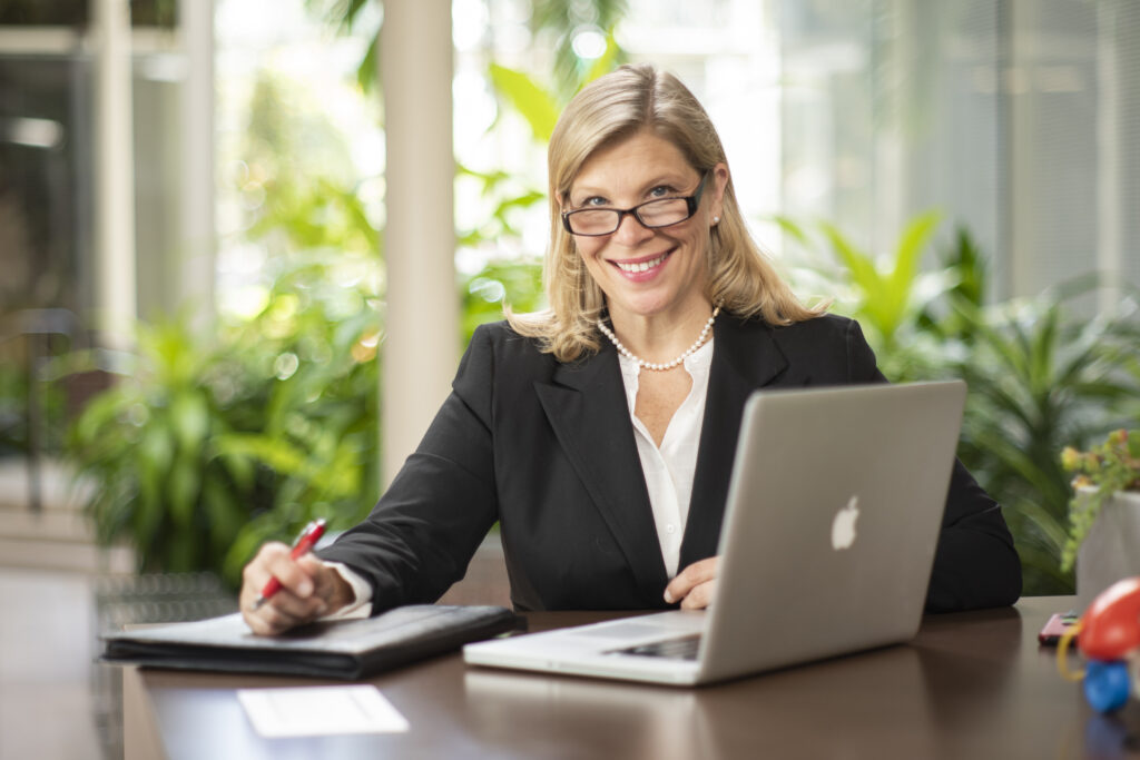 business woman at a desk with marketing proposals and a computer